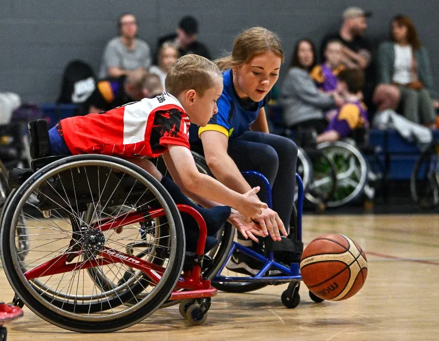 wheelchair basketball players posing with medals and trophy
